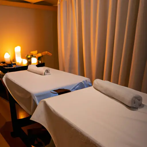  a serene, candle-lit room with plush white robes draped over two massage tables