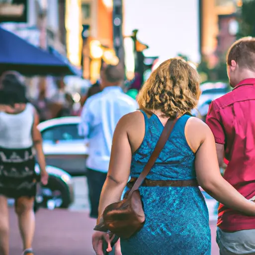 An image showcasing a couple discreetly holding hands while strolling down a bustling city sidewalk, surrounded by a diverse crowd