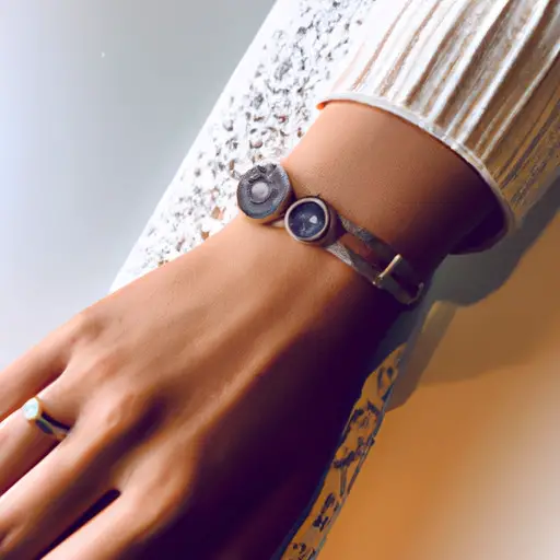 An image showcasing a chic wrist adorned with a delicate gold bracelet, paired with a stack of dainty rings and a trendy watch, all elegantly complementing a stylishly layered outfit for a casual dinner