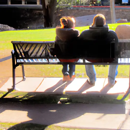 An image that depicts a couple sitting side by side on a park bench, their body language suggesting emotional distance