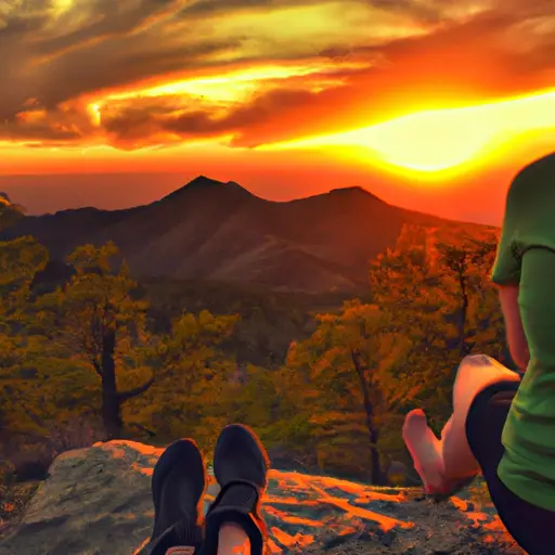 An image that captures the serenity of a person sitting cross-legged on a mountaintop, surrounded by a breathtaking sunset