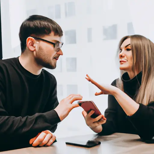 An image depicting a couple sitting face-to-face, one partner holding a phone, while the other expresses concern with open body language