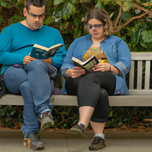 An image showcasing two people sitting side by side on a park bench, engrossed in their individual books